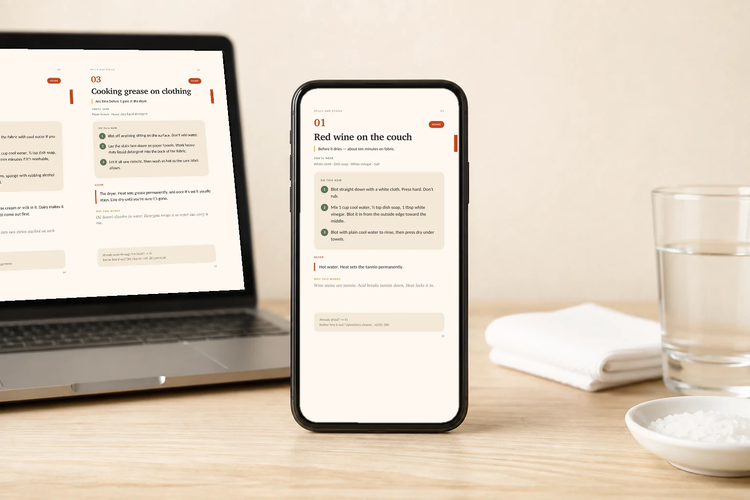 The HOME guide open on a phone beside a laptop, a folded cloth, a glass of water and a dish of salt